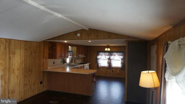 a view of a room with wooden floor and kitchen
