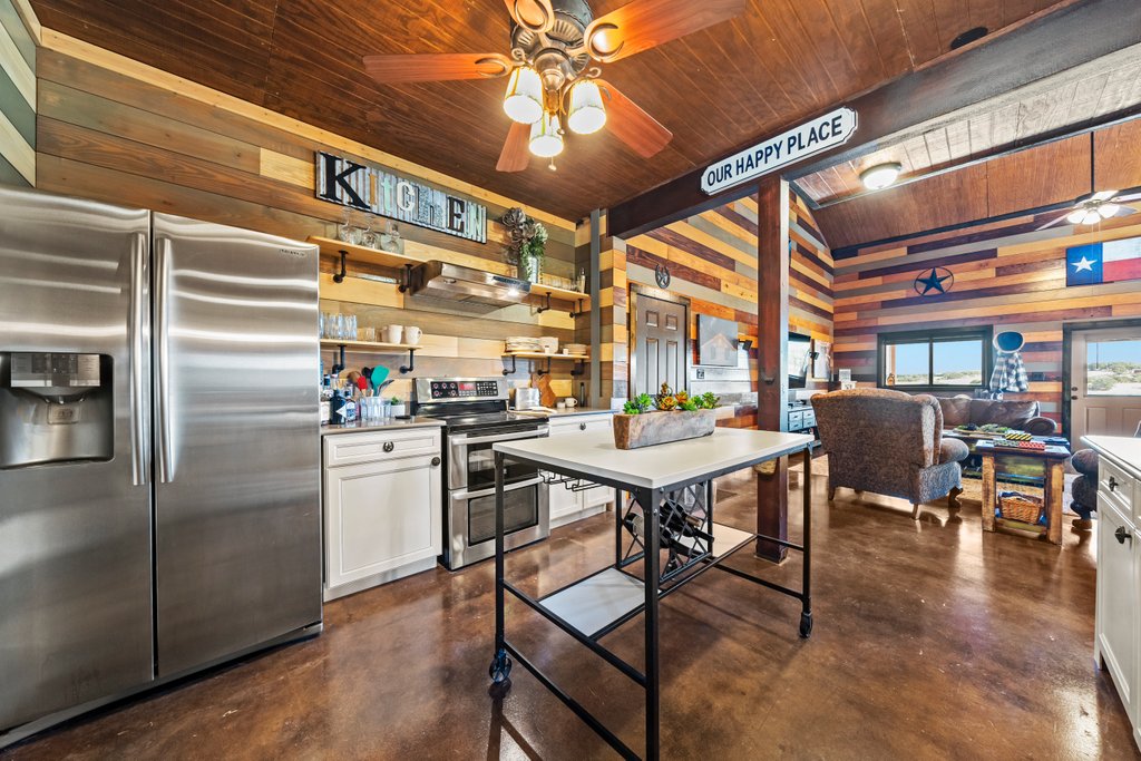 3259 Schumann Road Stonewall, TX 78671 - Photo 12 of 35 a view of a dining room with furniture window and wooden floor