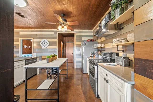 a kitchen with stainless steel appliances kitchen island granite countertop a sink a counter space and stainless steel appliances
