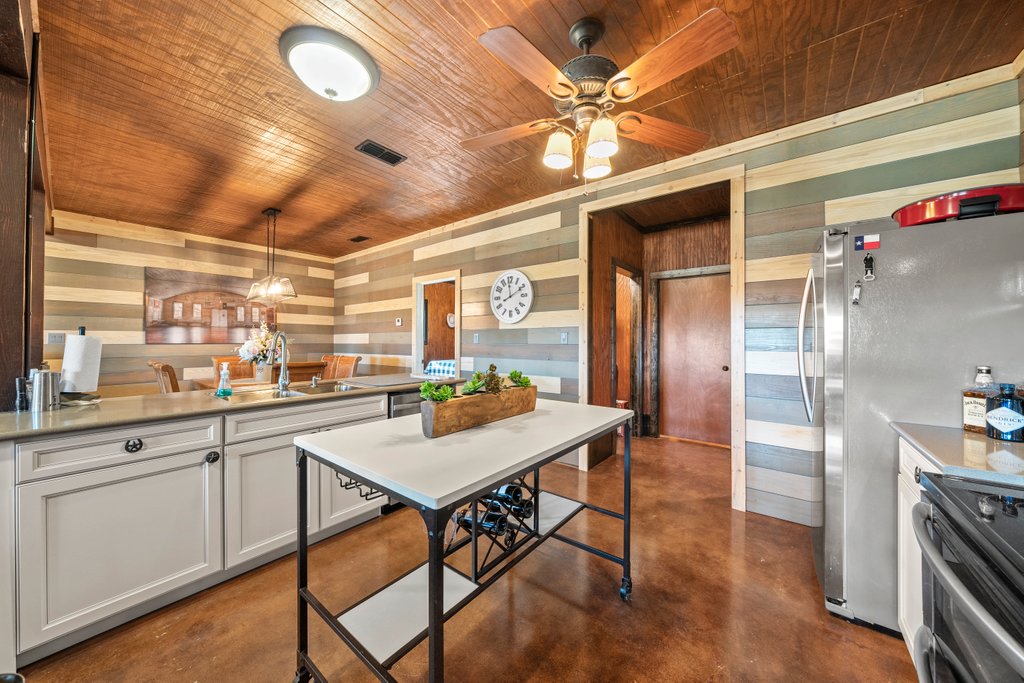 3259 Schumann Road Stonewall, TX 78671 - Photo 14 of 35 a kitchen with stainless steel appliances granite countertop a sink a stove and refrigerator