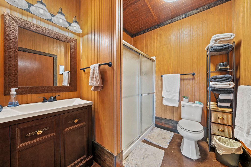 3259 Schumann Road Stonewall, TX 78671 - Photo 19 of 35 a bathroom with a toilet sink vanity granite and mirror