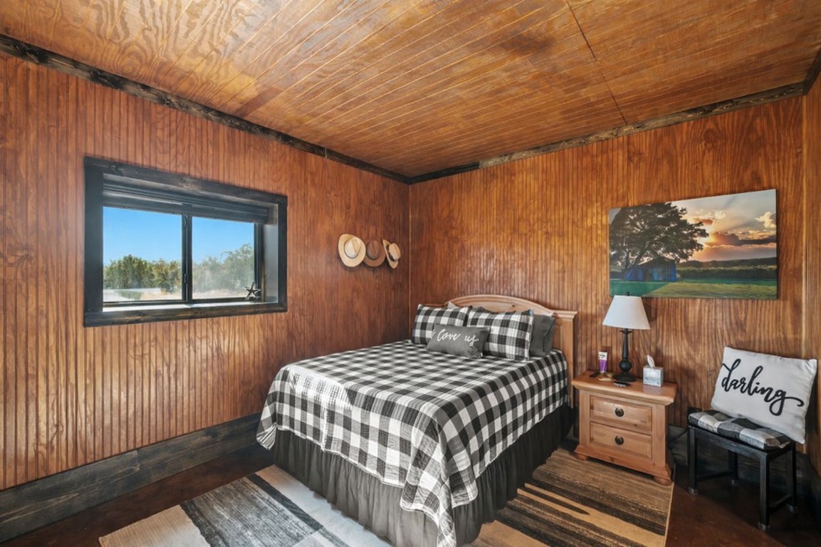 3259 Schumann Road Stonewall, TX 78671 - Photo 20 of 35 a bedroom with a bed and wooden floor