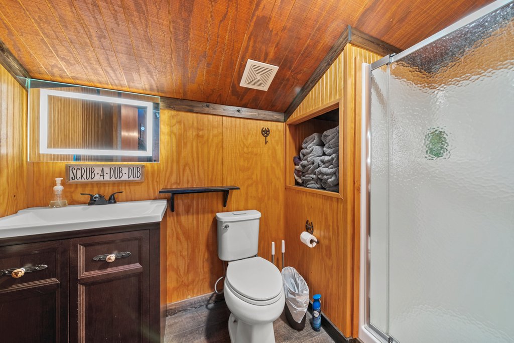 3259 Schumann Road Stonewall, TX 78671 - Photo 26 of 35 a bathroom with a granite countertop toilet sink and mirror