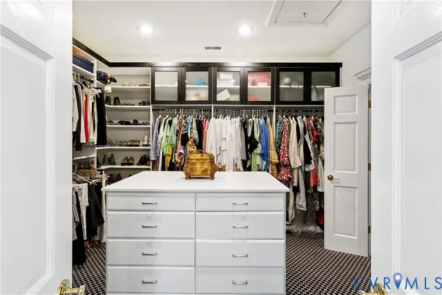 a view of walk in closet with clothes and shoes