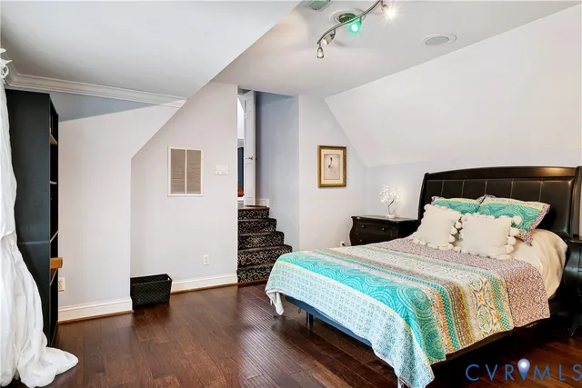 a bedroom with a bed and a wooden floor