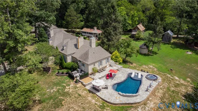 an aerial view of a house with swimming pool and garden