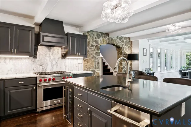a kitchen with kitchen island granite countertop a stove and a sink