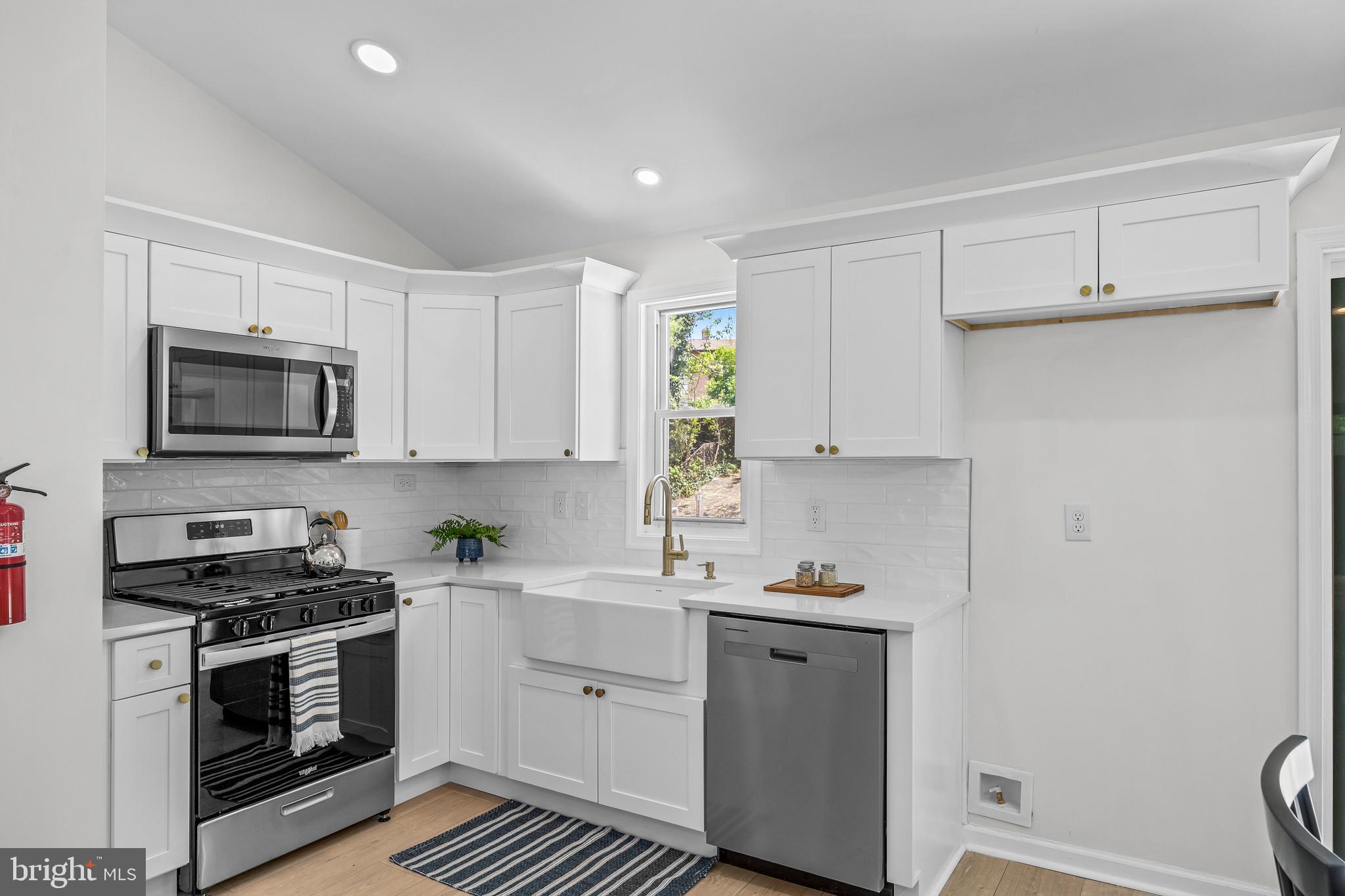 219 Somerset Road Woodbury, NJ 08096 - Photo 6 of 13 a kitchen with white cabinets stainless steel appliances and sink