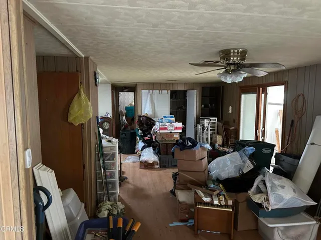 an empty room with windows and chandelier fan