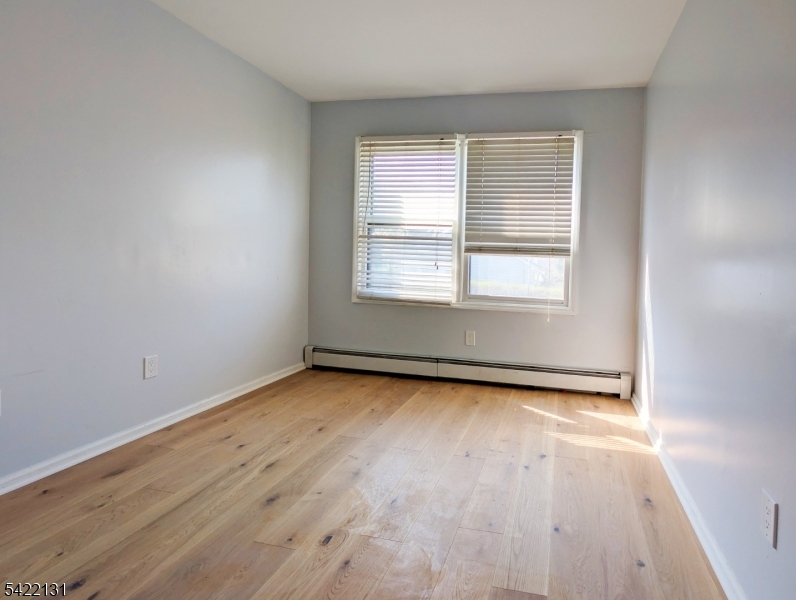 39 Church Street, Unit A Millburn, NJ 07041 - Photo 10 of 14 an empty room with wooden floor and windows