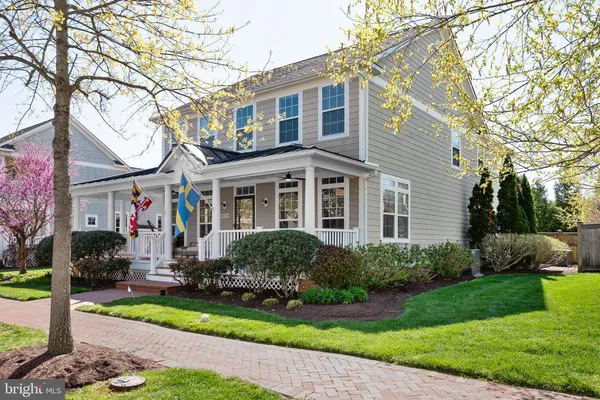 a front view of a house with a yard and trees