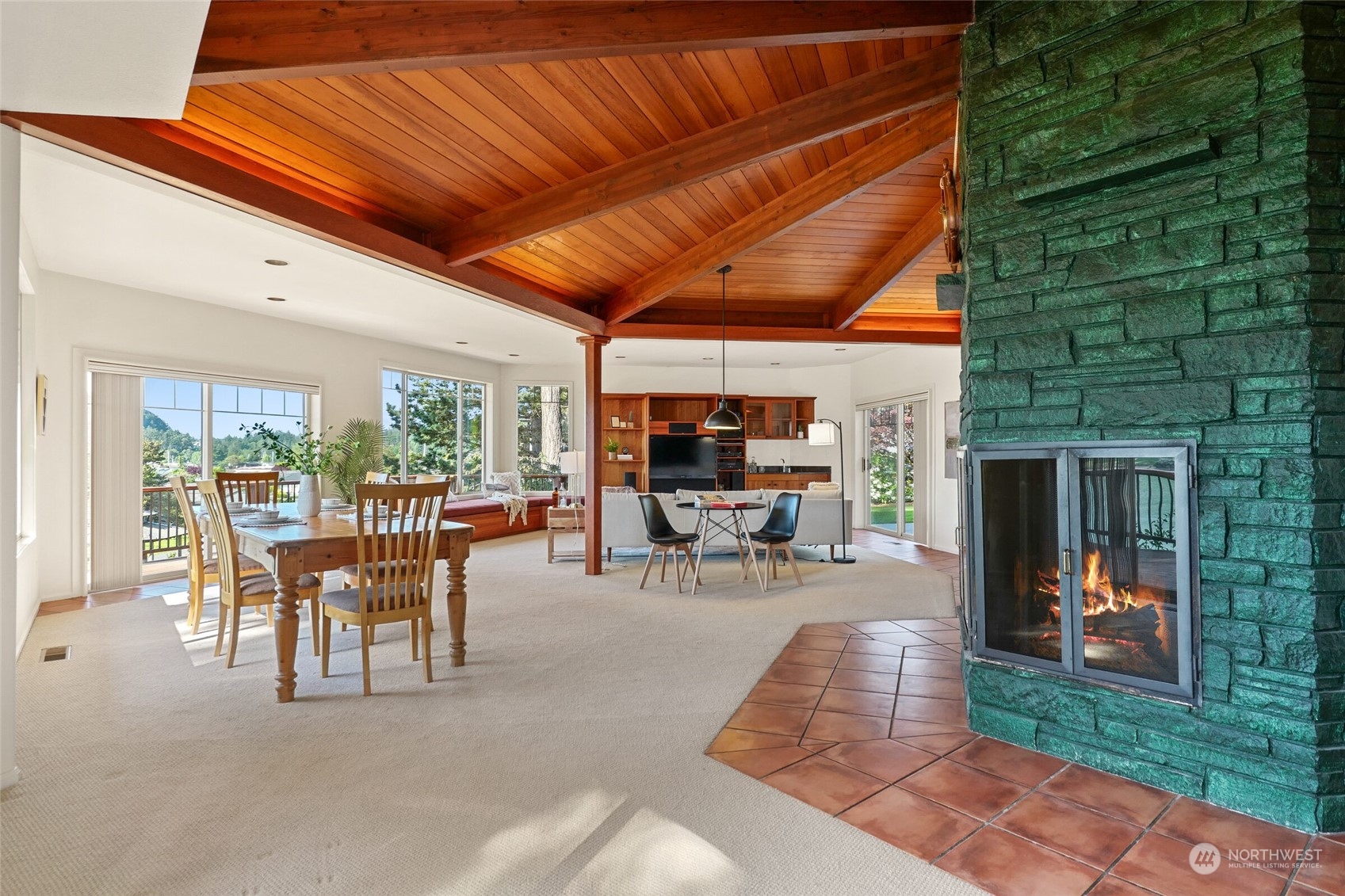 97 Samish Place La Conner, WA 98257 - Photo 10 of 40 a view of a patio with table and chairs potted plants with floor to ceiling window