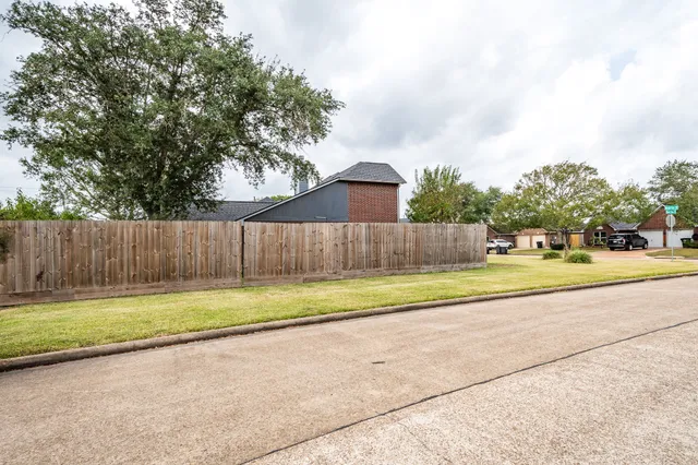 a view of a yard with wooden fence