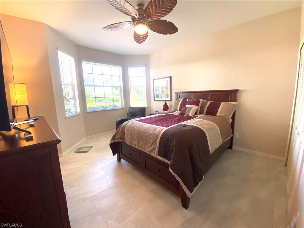 19307 Silver Oak Drive Estero, FL 33967 - Photo 24 of 43 a bedroom with a bed lamp and a chandelier