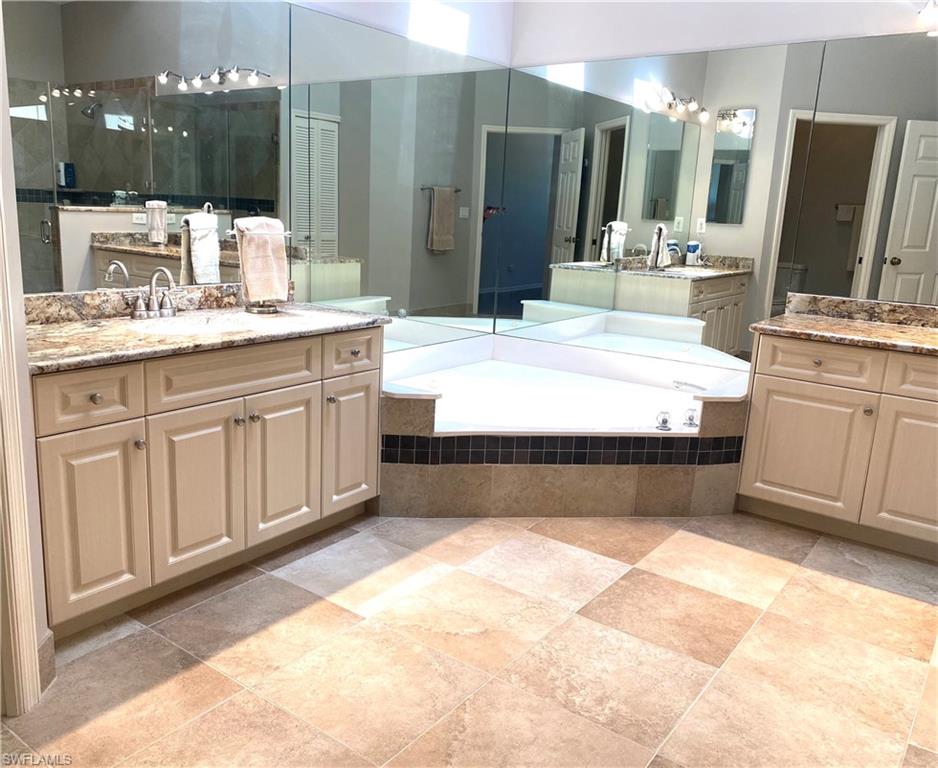 19307 Silver Oak Drive Estero, FL 33967 - Photo 28 of 43 a bathroom with a bathtub sink and mirror