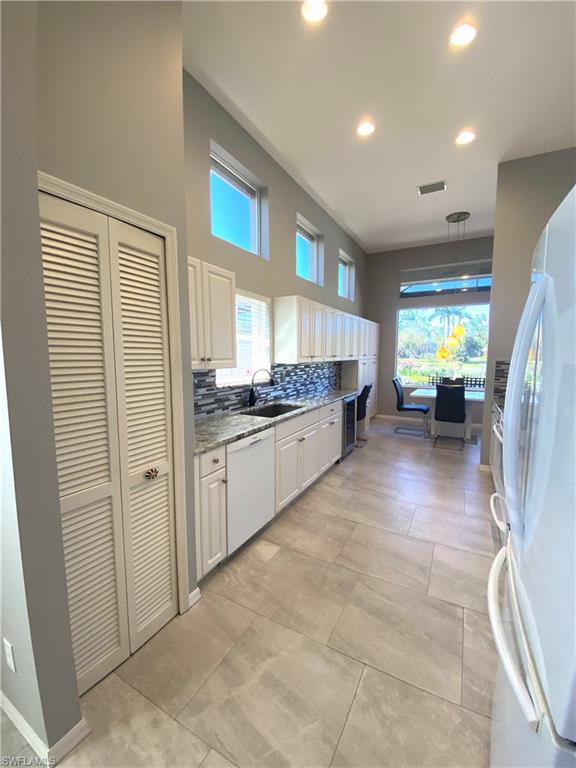 19307 Silver Oak Drive Estero, FL 33967 - Photo 10 of 43 a large white kitchen with cabinets and a refrigerator