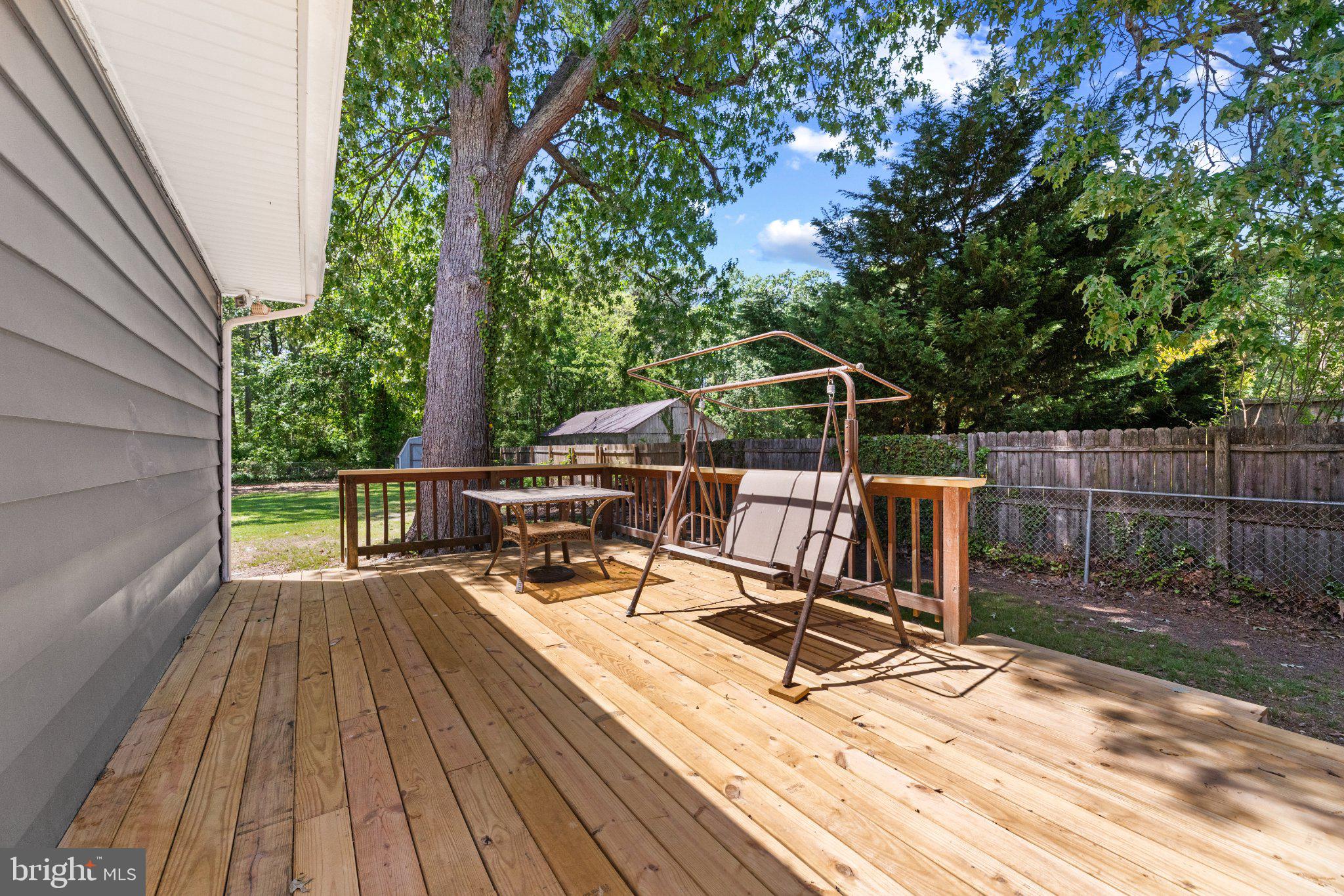 12 Oak Street Cambridge, MD 21613 - Photo 6 of 26 Serene deck with lush greenery backdrop.