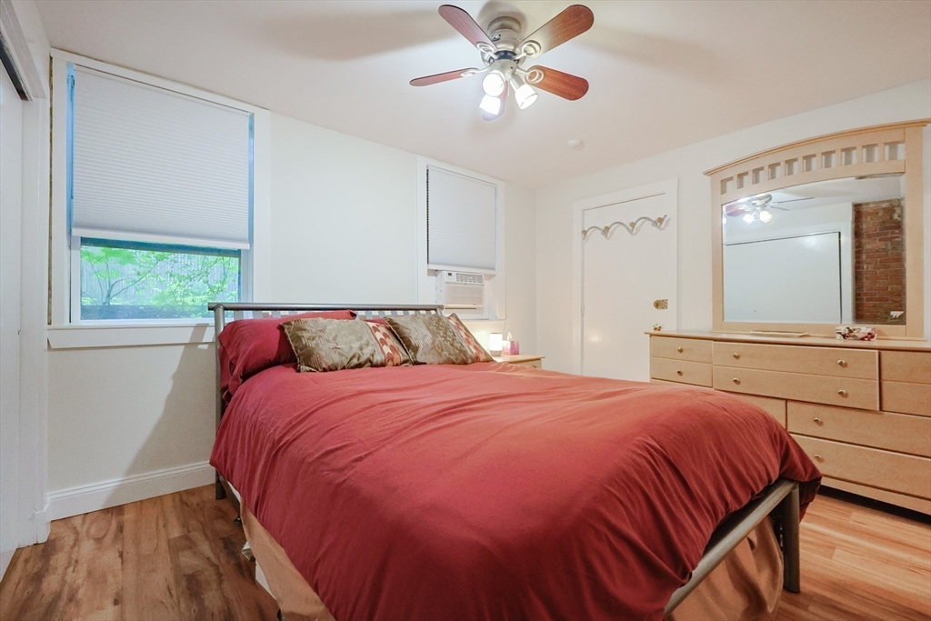 33 Inman Street, Unit 1B Cambridge, MA 02139 - Photo 11 of 12 a bedroom with a large bed and a chandelier