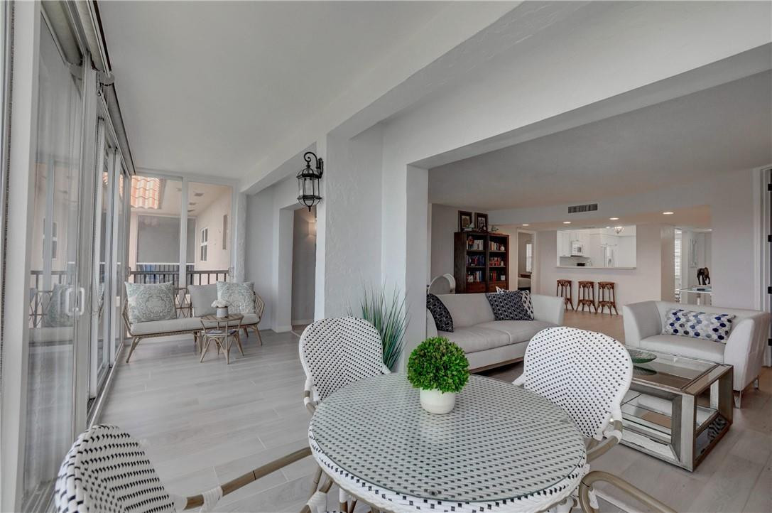 2871 North Ocean Boulevard, Unit C519 Boca Raton, FL 33431 - Photo 13 of 36 a living room with furniture a table and kitchen view