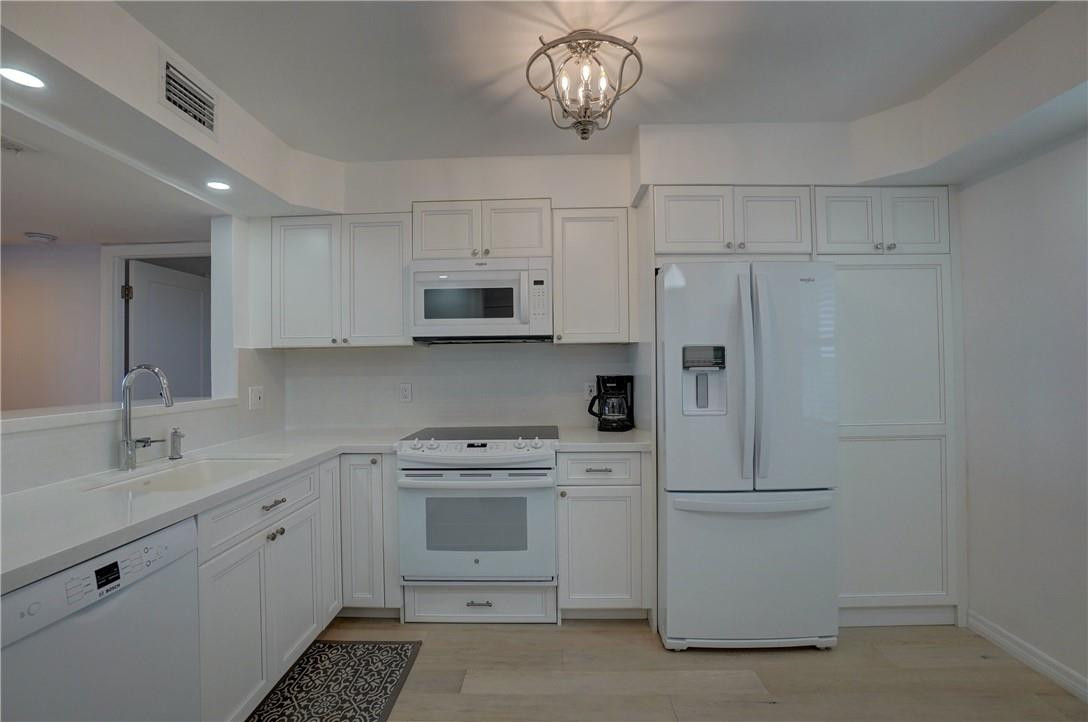 2871 North Ocean Boulevard, Unit C519 Boca Raton, FL 33431 - Photo 2 of 36 a kitchen with white cabinets and white appliances