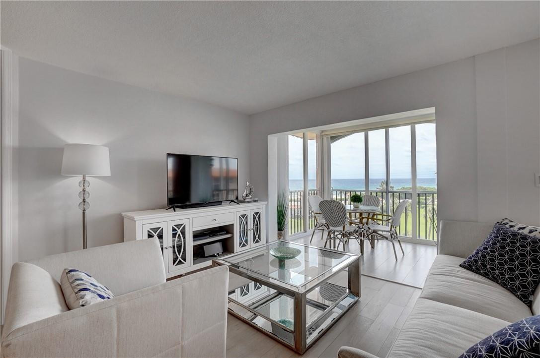 2871 North Ocean Boulevard, Unit C519 Boca Raton, FL 33431 - Photo 6 of 36 a living room with furniture a flat screen tv and a large window
