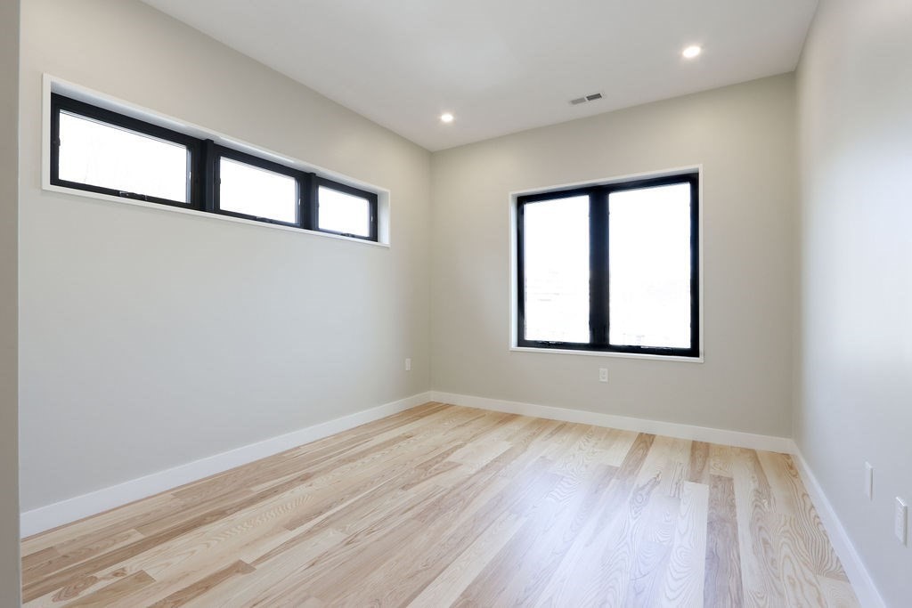 41 Nathan Road, Unit 1 Waltham, MA 02453 - Photo 22 of 25 an empty room with wooden floor and windows