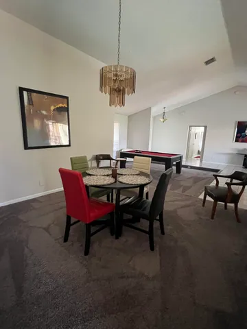 a view of a dining room with furniture and chandelier