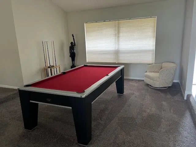 a room with pool table and windows