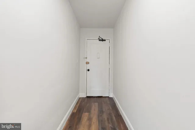 a view of a hallway with wooden floor