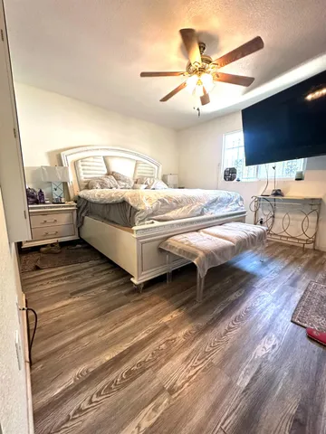 a living room with a bed furniture and a flat screen tv