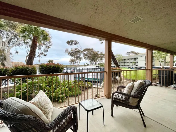 a balcony view with a large window and chairs
