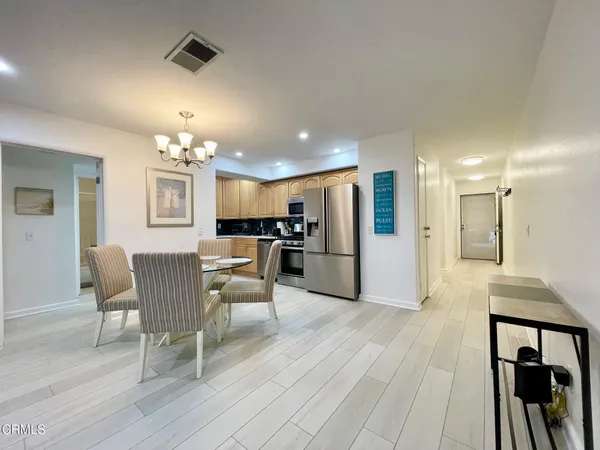 a dining room with furniture and kitchen view