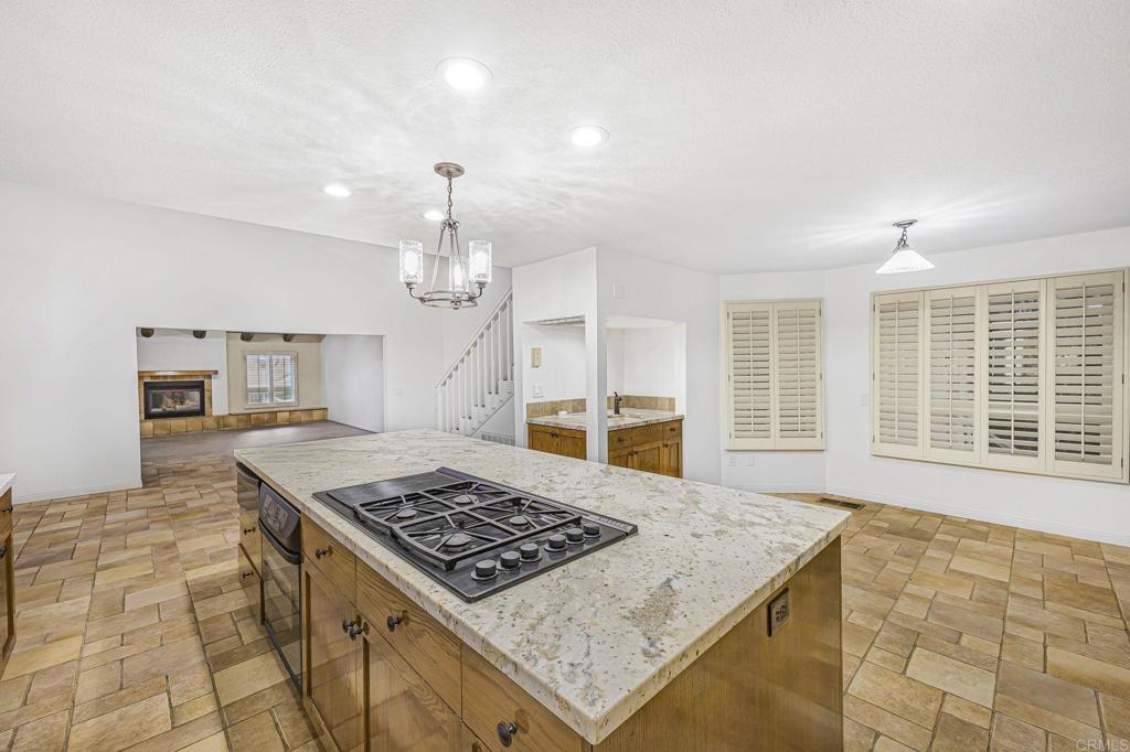 28720 Sandhurst Way Escondido, CA 92026 - Photo 26 of 57 a kitchen with kitchen island a counter top space a sink stainless steel appliances and cabinets