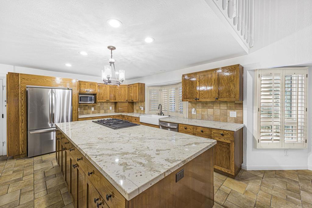 28720 Sandhurst Way Escondido, CA 92026 - Photo 28 of 57 a kitchen with stainless steel appliances granite countertop kitchen island a stove and a sink