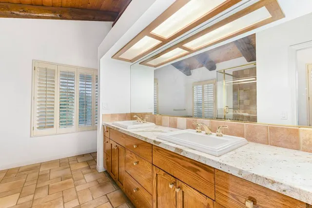 an empty room with wooden floor and fan