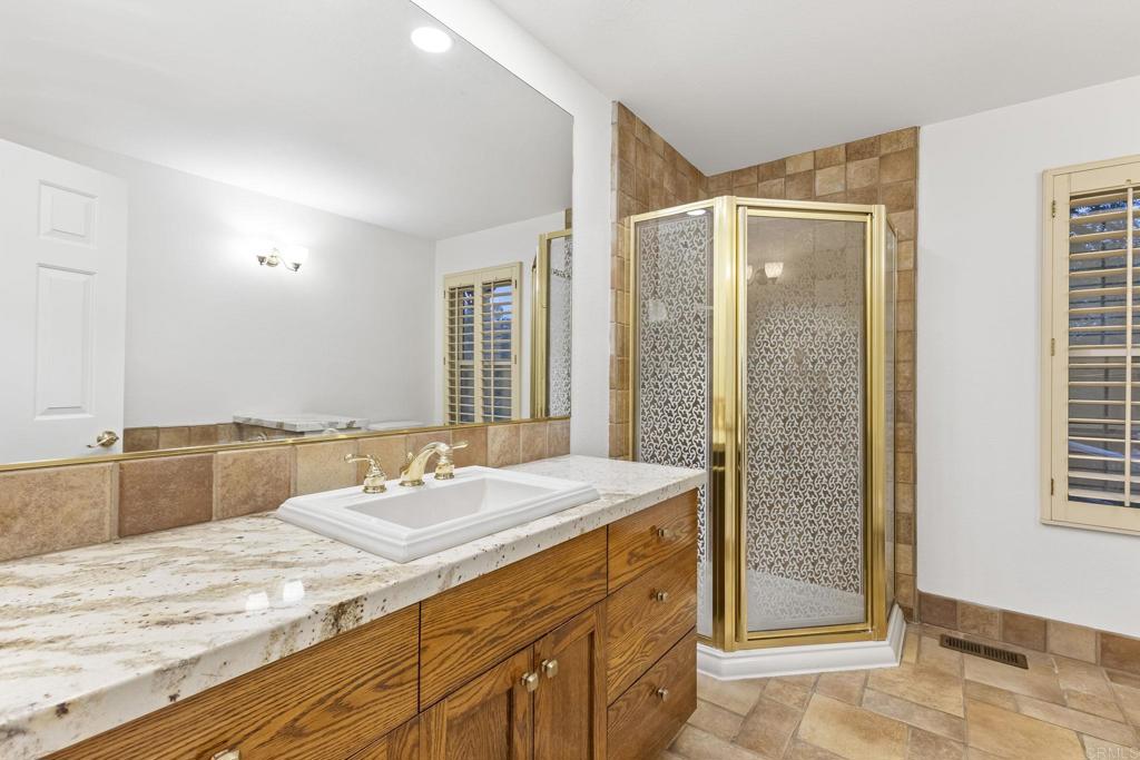 28720 Sandhurst Way Escondido, CA 92026 - Photo 47 of 57 a bathroom with a granite countertop sink and a mirror