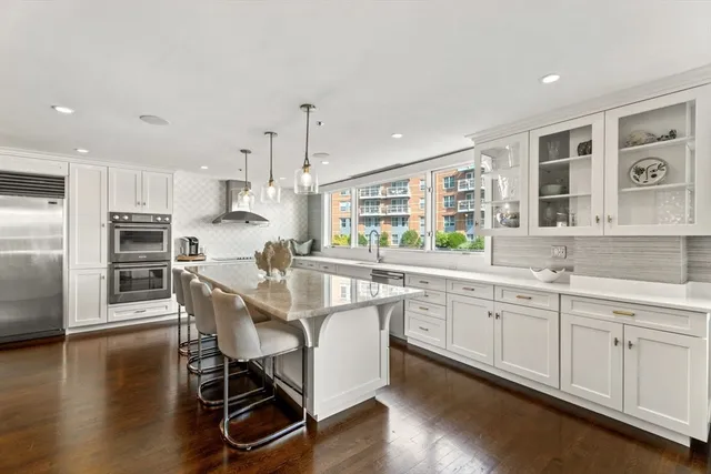 a kitchen with stainless steel appliances granite countertop a kitchen island hardwood floor sink and stove