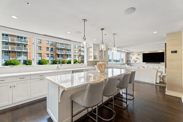 a dining area with a table chairs and a kitchen view