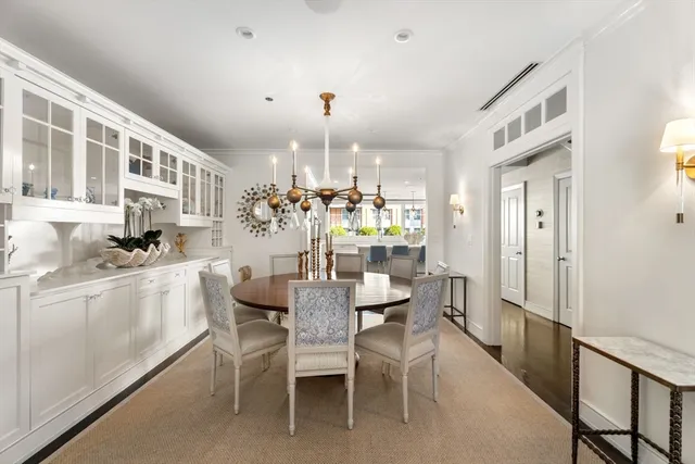 a kitchen with a dining table chairs cabinets and stainless steel appliances