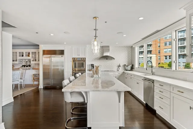 a kitchen with stainless steel appliances kitchen island granite countertop a sink and refrigerator