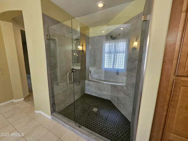 an empty room with a chandelier fan and windows