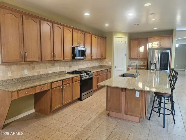 a kitchen with stainless steel appliances granite countertop wooden cabinets a sink and a stove