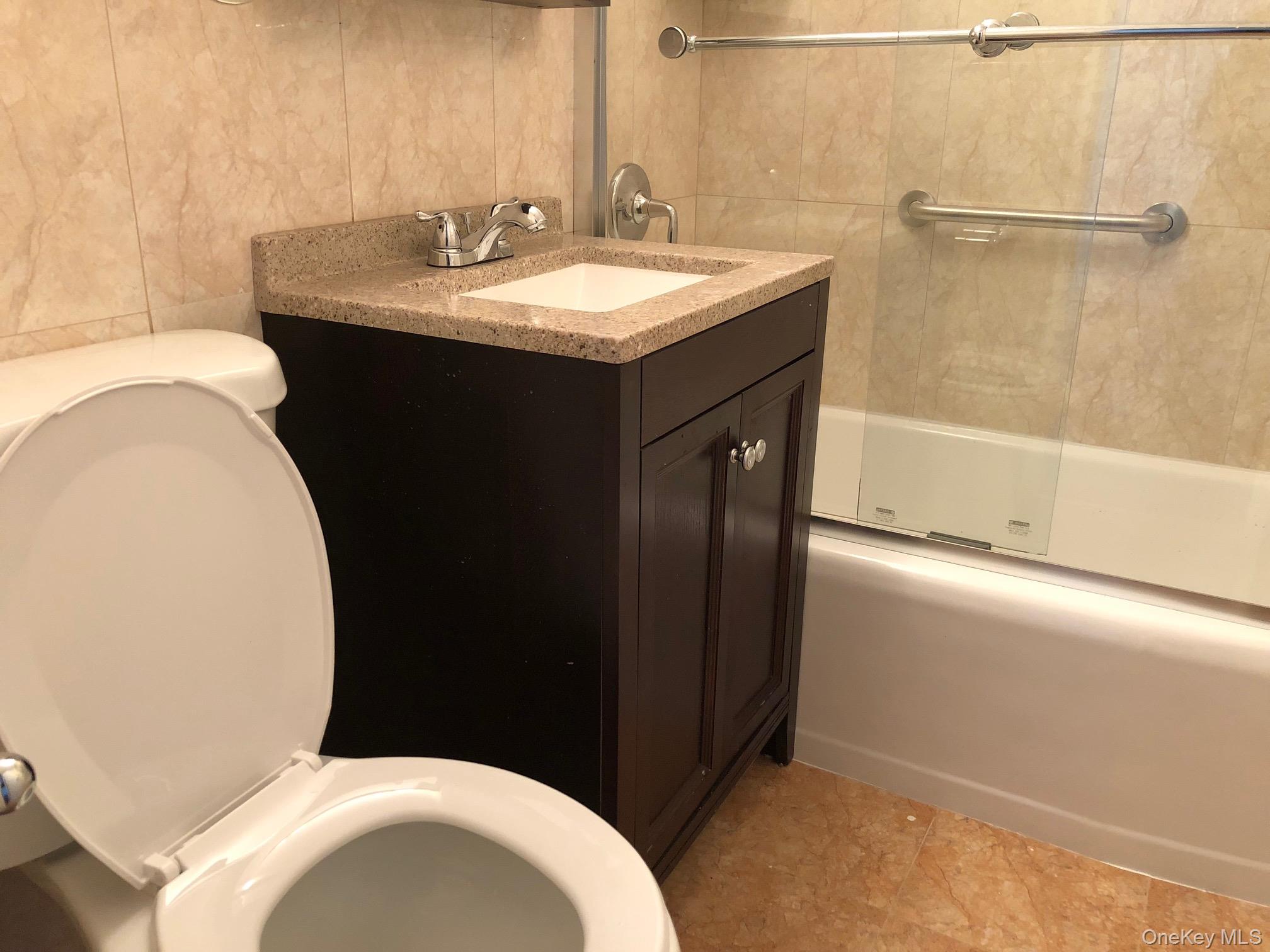 97-10 62nd Drive, Unit 9C Queens, NY 11374 - Photo 6 of 11 a bathroom with a sink and a toilet