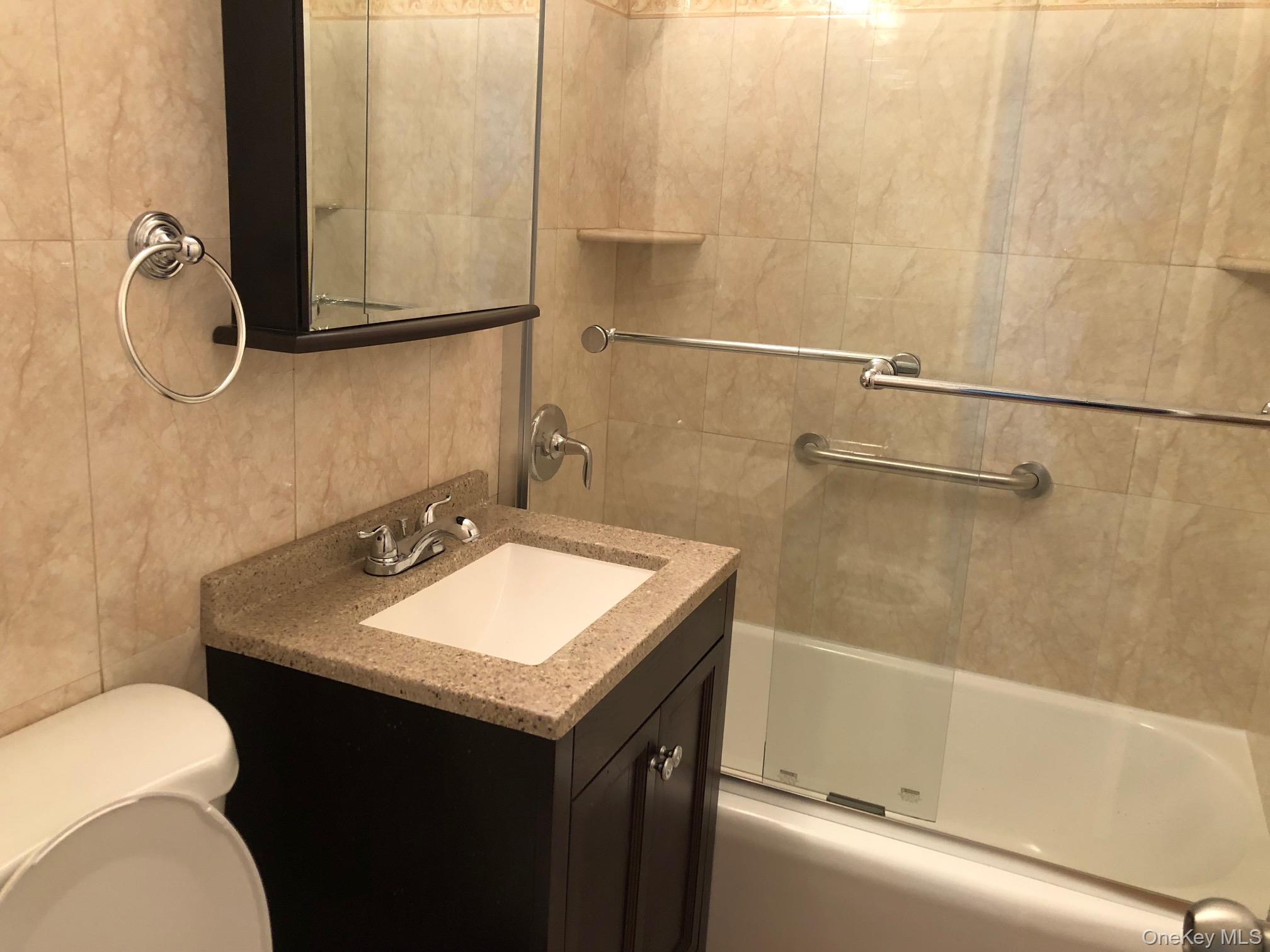 97-10 62nd Drive, Unit 9C Queens, NY 11374 - Photo 7 of 11 a bathroom with a sink toilet and shower