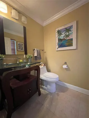 a bathroom with a granite countertop toilet sink and mirror