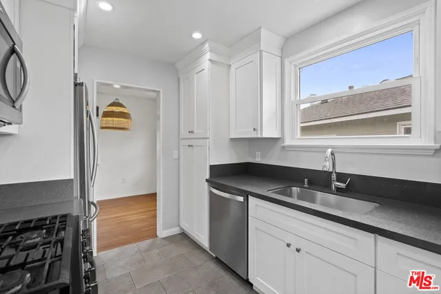 a kitchen with granite countertop a sink and a stove