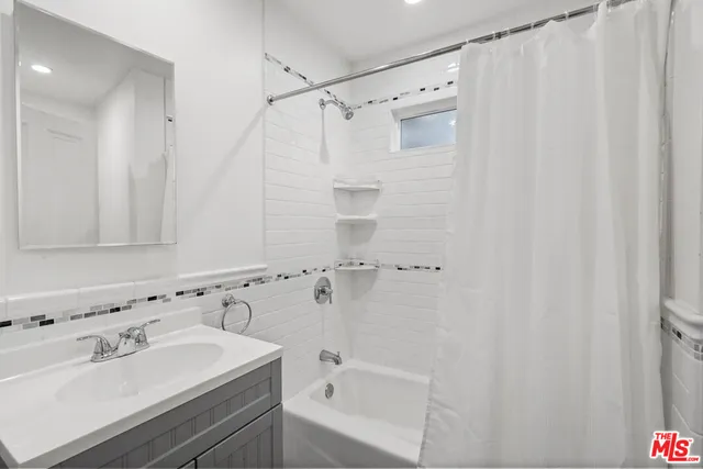 a bathroom with a sink mirror and shower