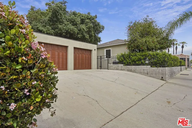 a view of a house with a yard and potted plants
