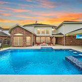 a view of a house with pool and sitting area