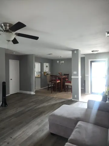 a living room with furniture and a view of kitchen